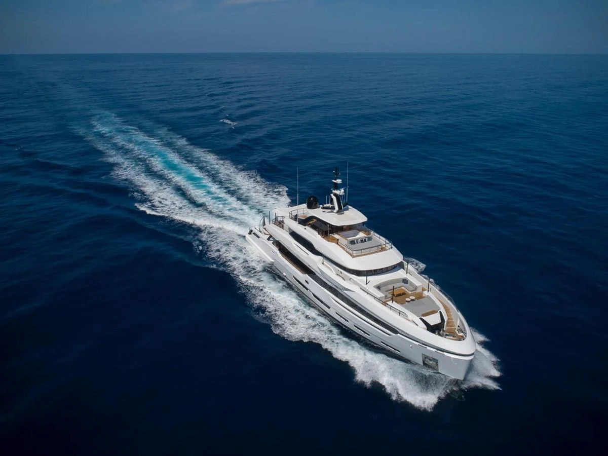 A luxurious yacht cruises through the open sea, leaving a trail of white wake behind. aboard ATTITUDE Yacht for Sale