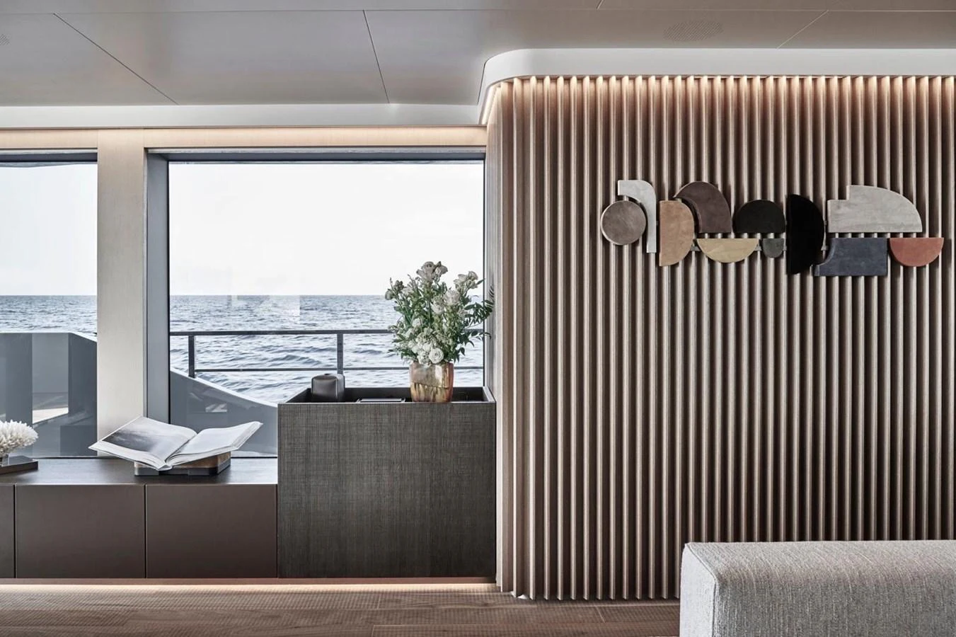 The yacht's interior features a modern design with a view of the sea through large windows. aboard ATTITUDE Yacht for Sale