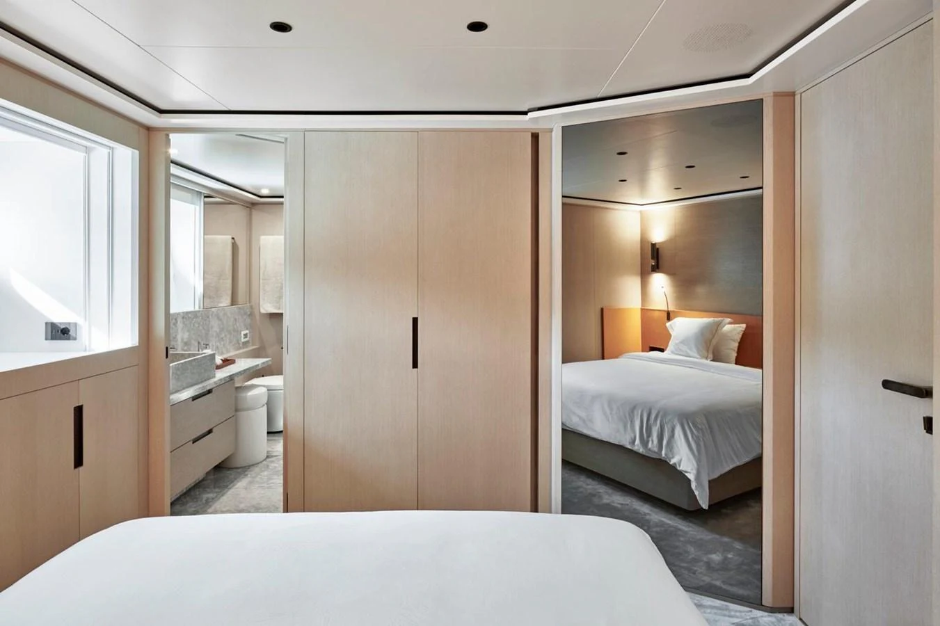 The stateroom features a serene and modern design with light wood finishes and ample natural light. aboard ATTITUDE Yacht for Sale