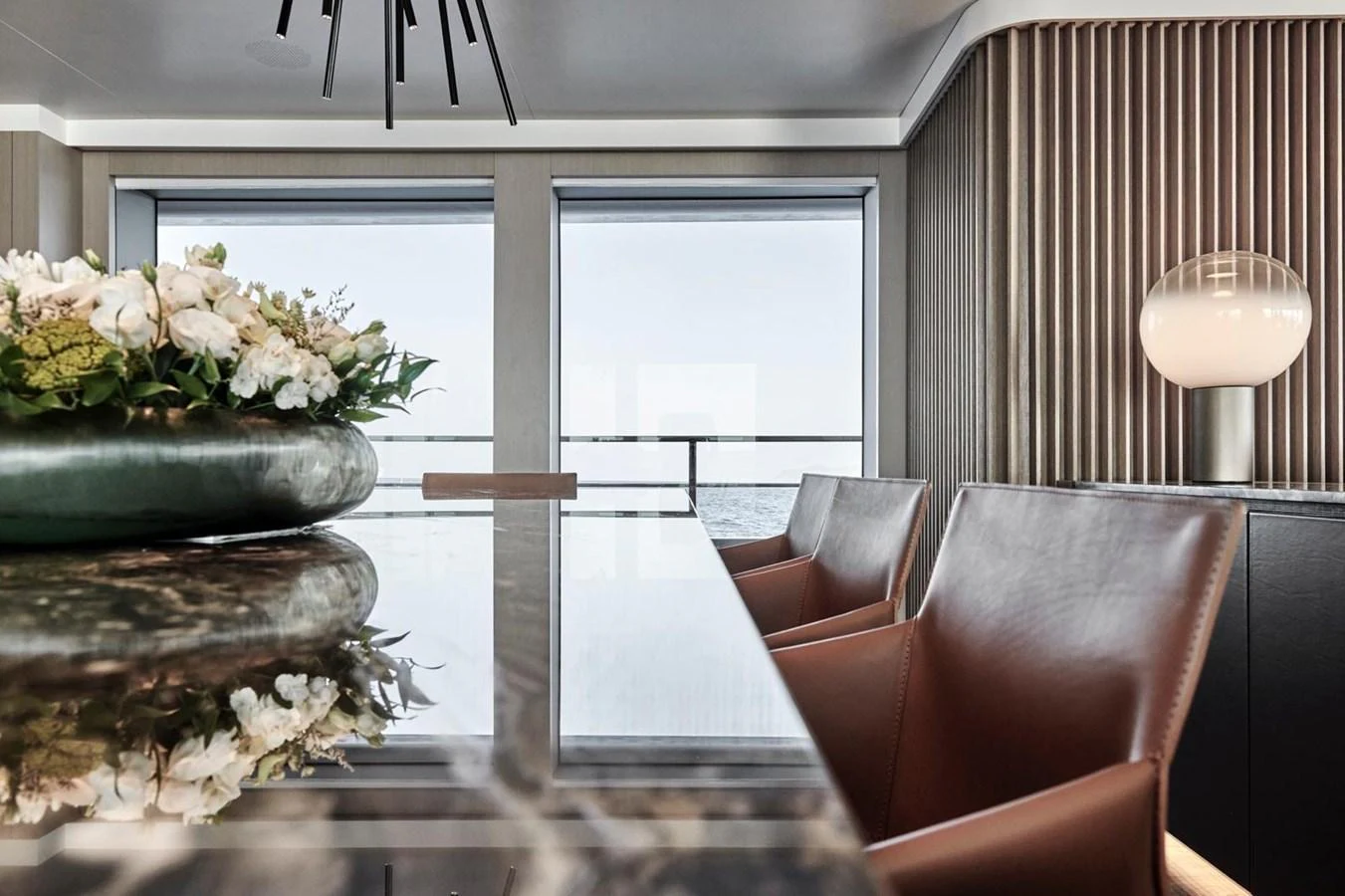 The yacht's interior features a sophisticated dining area with large windows offering stunning sea views. aboard ATTITUDE Yacht for Sale