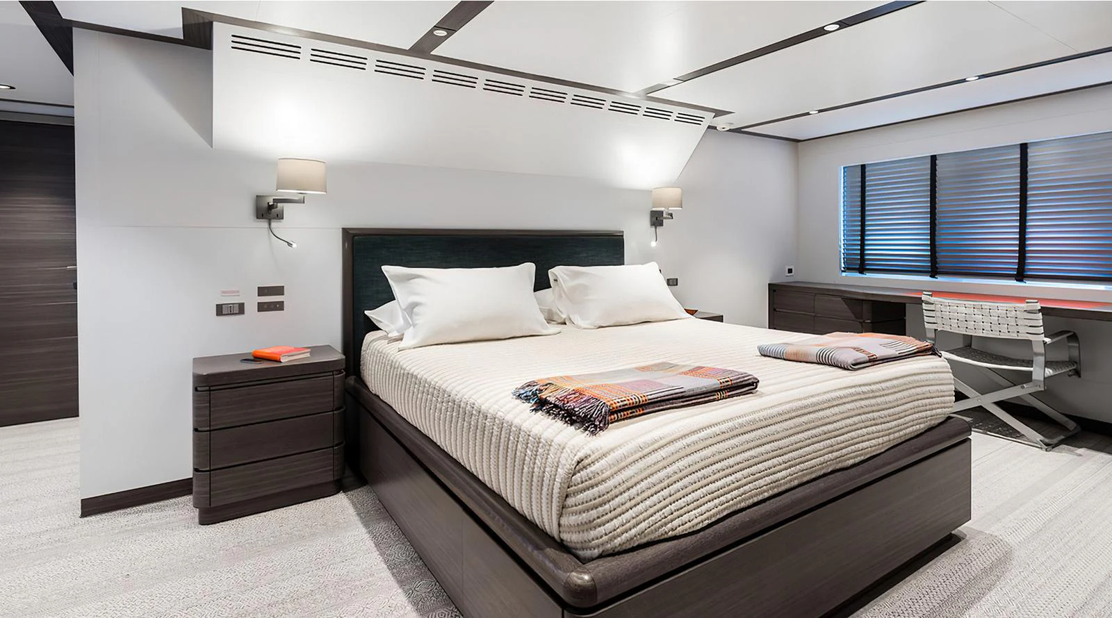 The stateroom features a luxurious bed with modern furnishings and ample natural light. aboard EXPLORER 130 Yacht for Sale