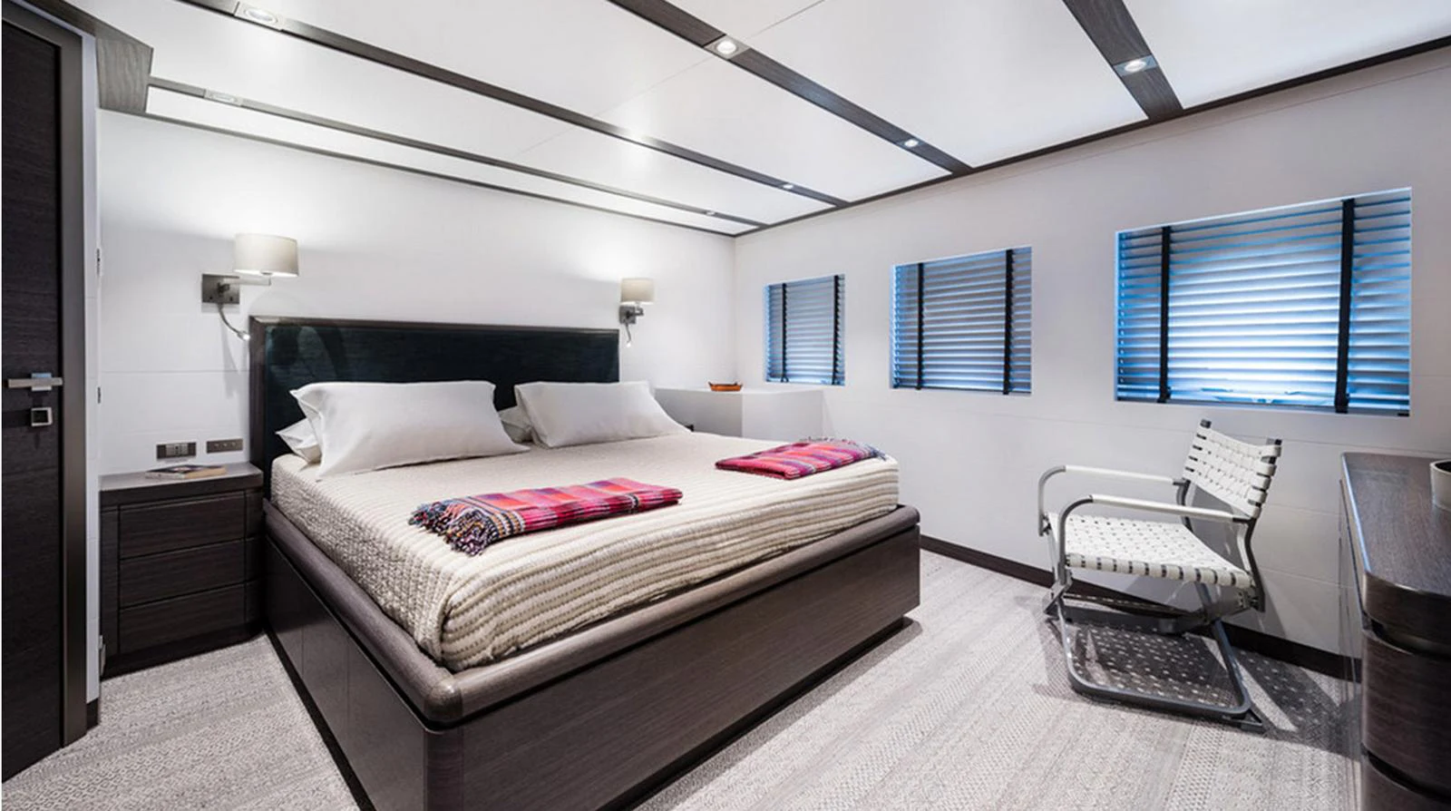 The stateroom features a spacious bed with modern furnishings and ample natural light from multiple windows. aboard EXPLORER 130 Yacht for Sale