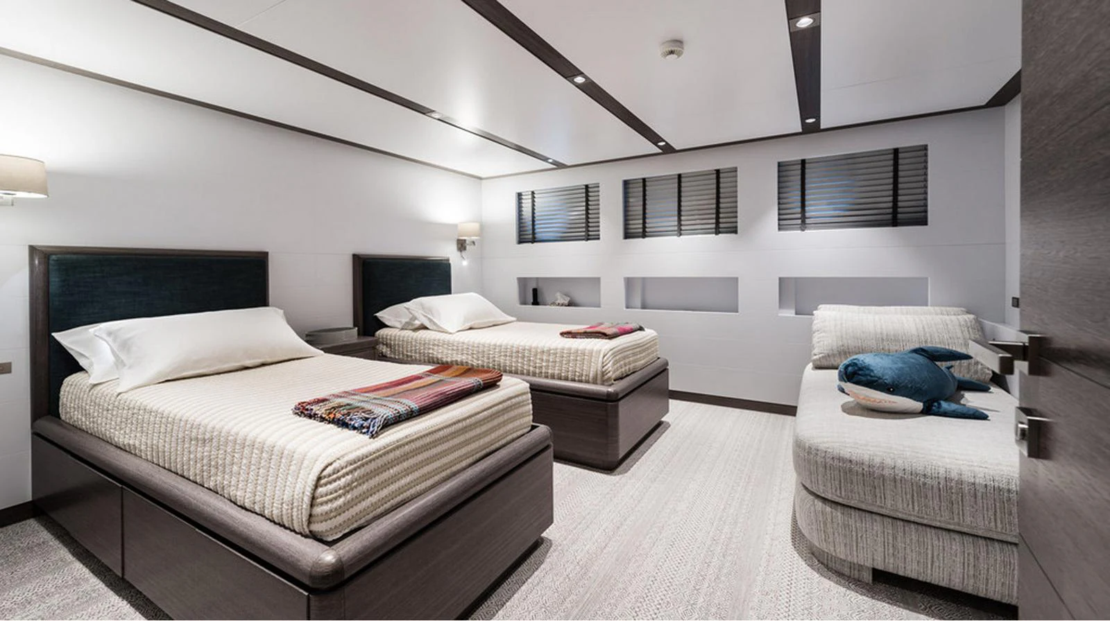 The guest stateroom features twin beds and a cozy seating area, offering a serene and comfortable retreat. aboard EXPLORER 130 Yacht for Sale