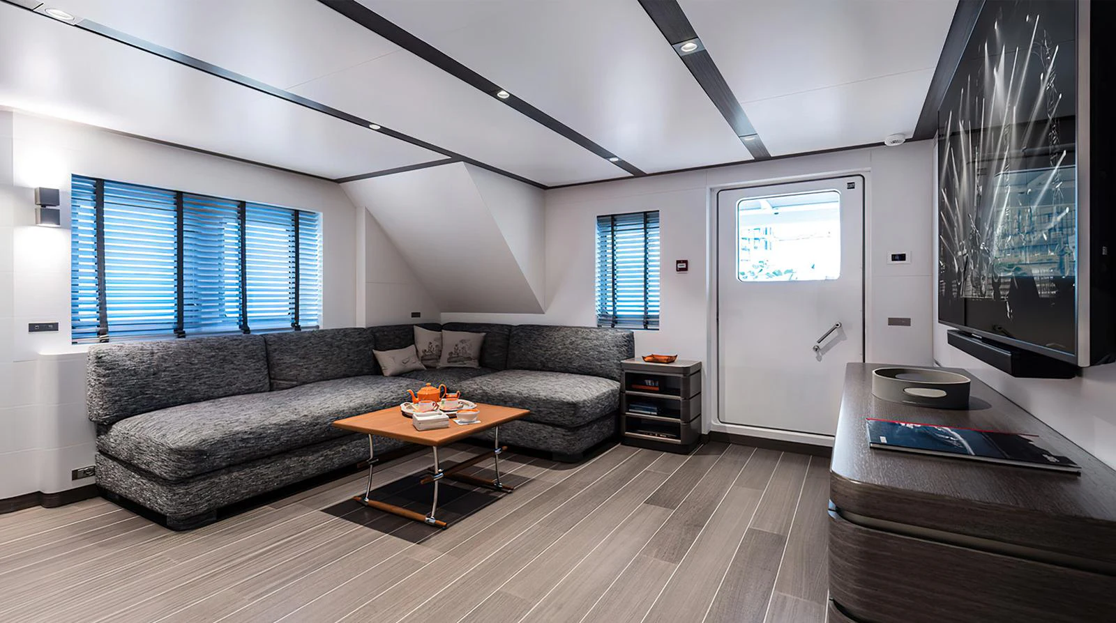 The salon features a spacious and modern seating area with a large sectional sofa and a sleek coffee table. aboard EXPLORER 130 Yacht for Sale