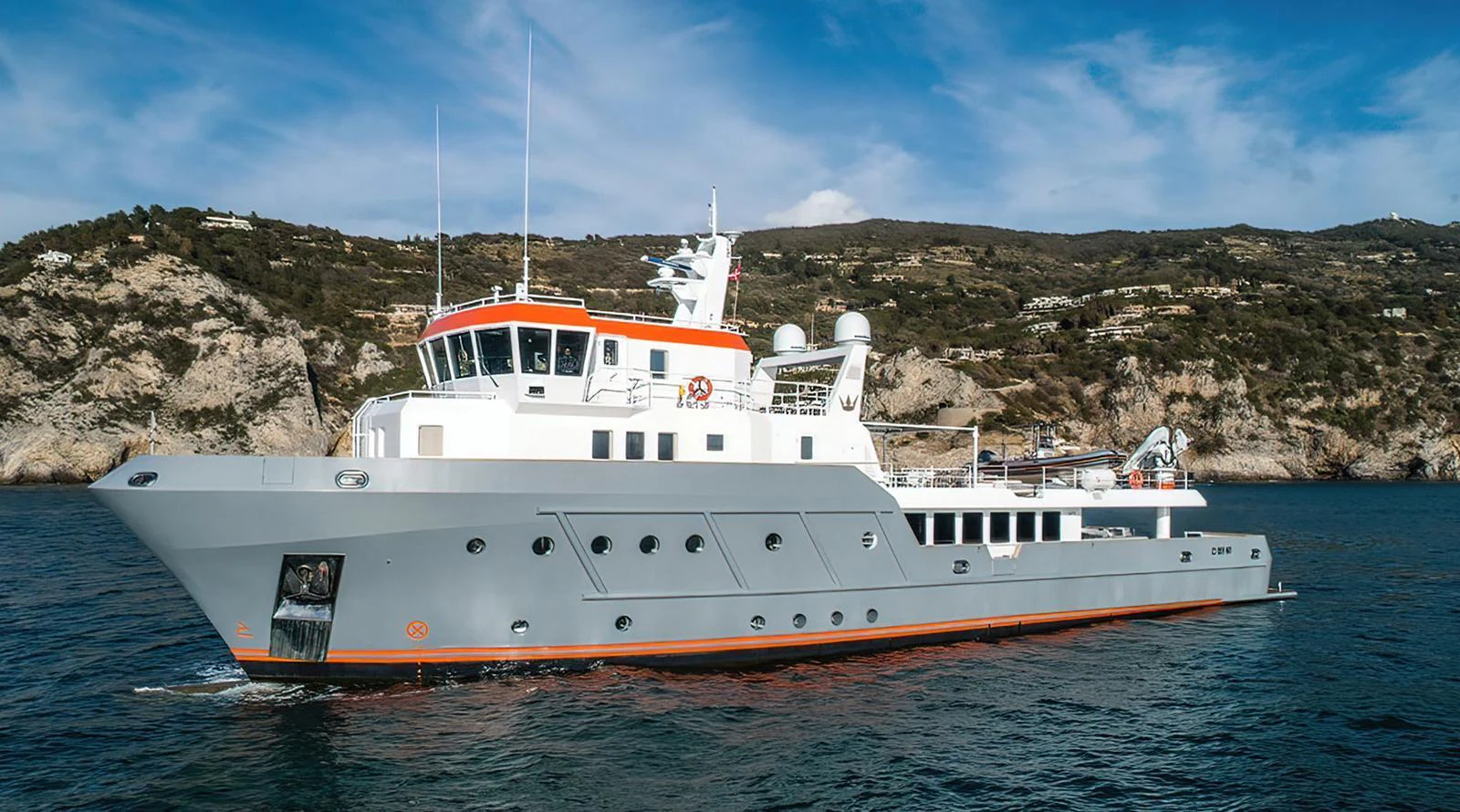 A robust and stylish yacht cruising along a scenic coastline. aboard EXPLORER 130 Yacht for Sale