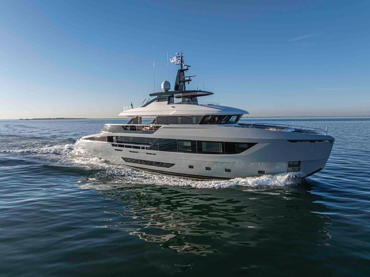 A sleek and modern yacht glides smoothly over calm waters under a clear blue sky. aboard DOGE 500 Yacht for Sale