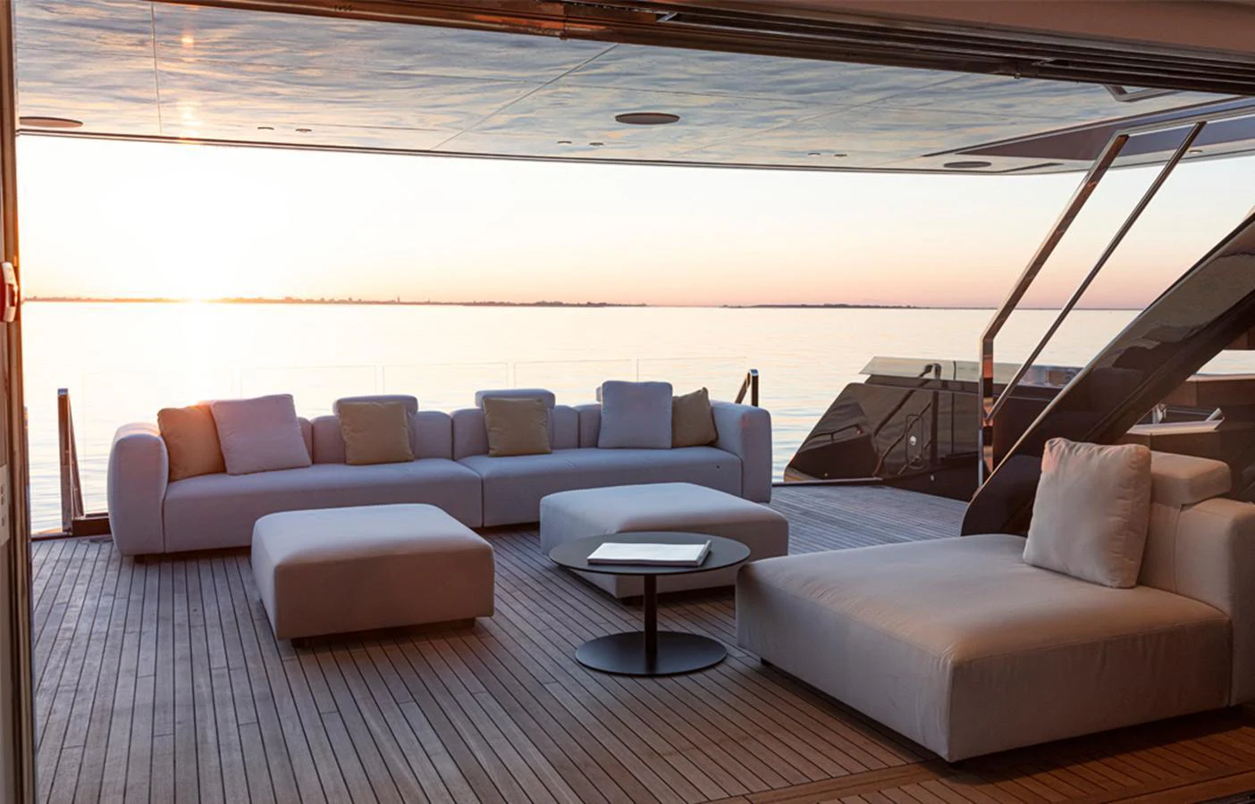 The aft deck offers a serene lounging area with plush seating and a stunning view of the sunset over the water. aboard DOGE 500 Yacht for Sale