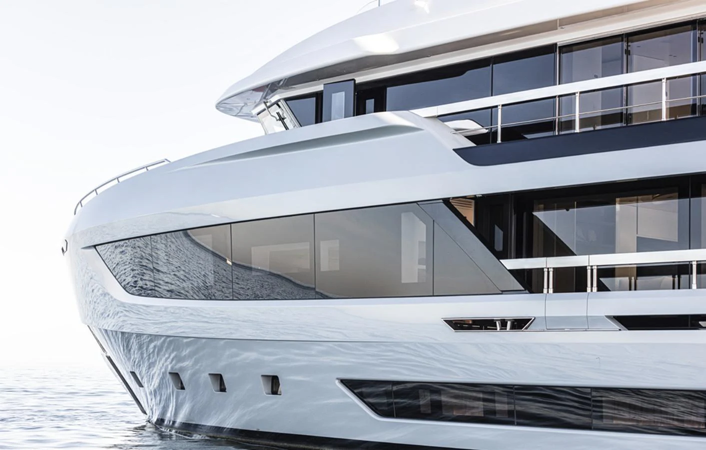 A sleek and modern yacht with large windows and a streamlined design glides through calm waters. aboard DOGE 500 Yacht for Sale