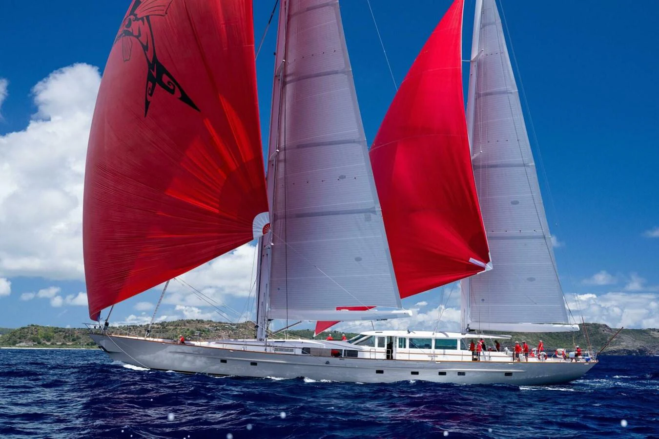 A stunning sailing yacht with vibrant red sails glides gracefully on the open sea. aboard CATALINA Yacht for Sale