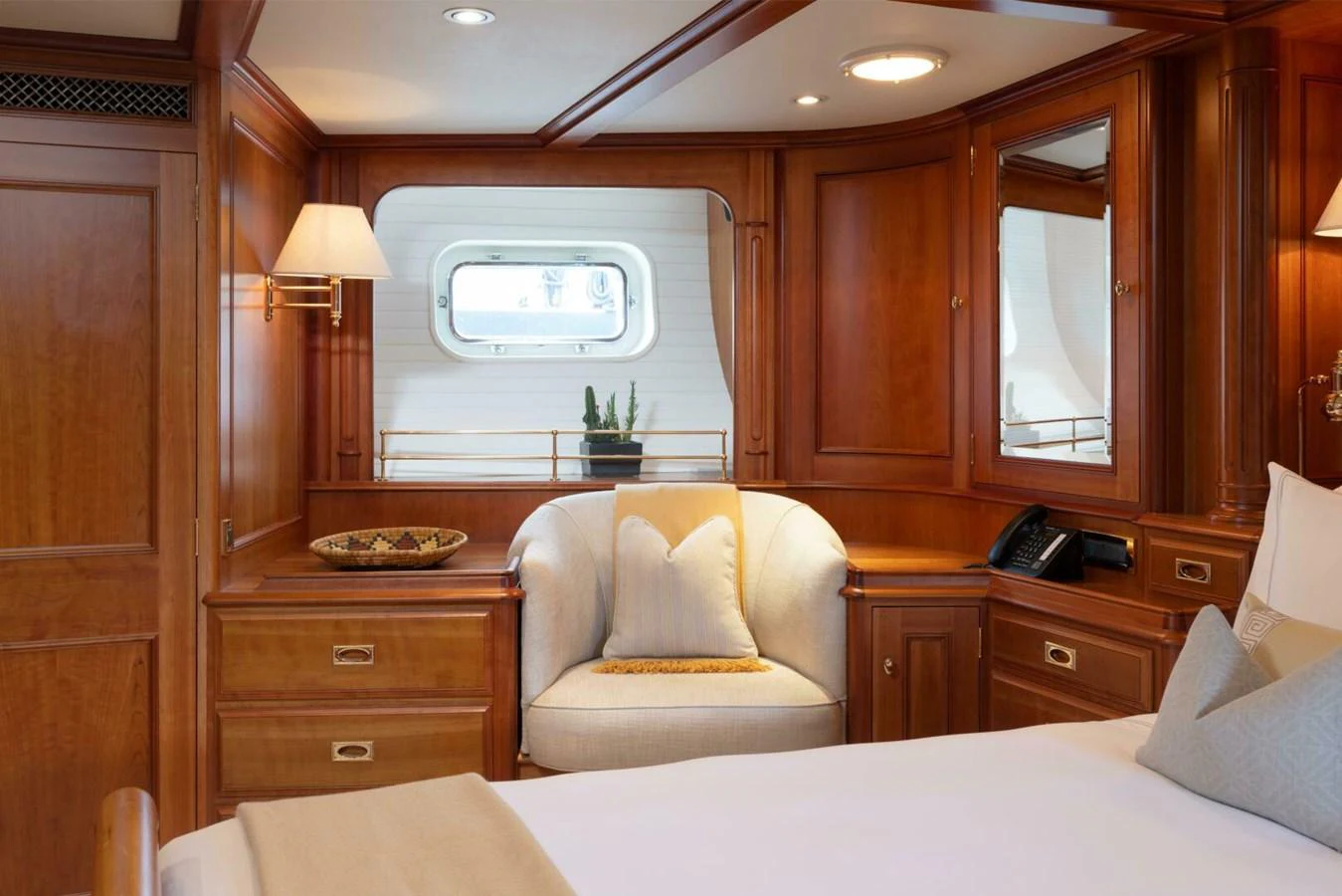The stateroom features elegant wooden cabinetry and a cozy seating area by the window. aboard CATALINA Yacht for Sale