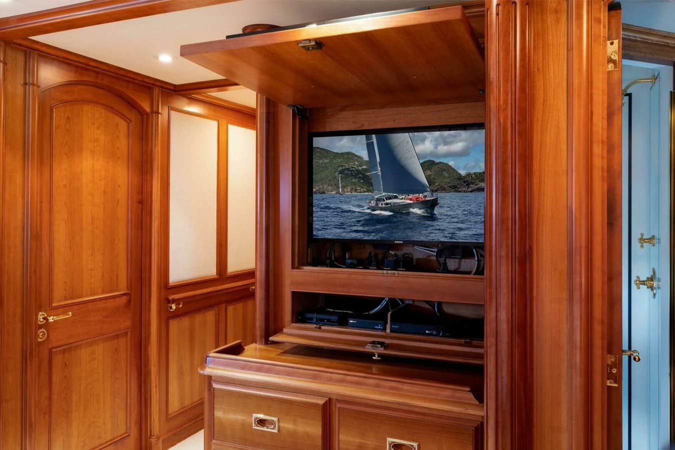 A luxurious wooden interior with a hidden television displaying a sailing yacht. aboard CATALINA Yacht for Sale