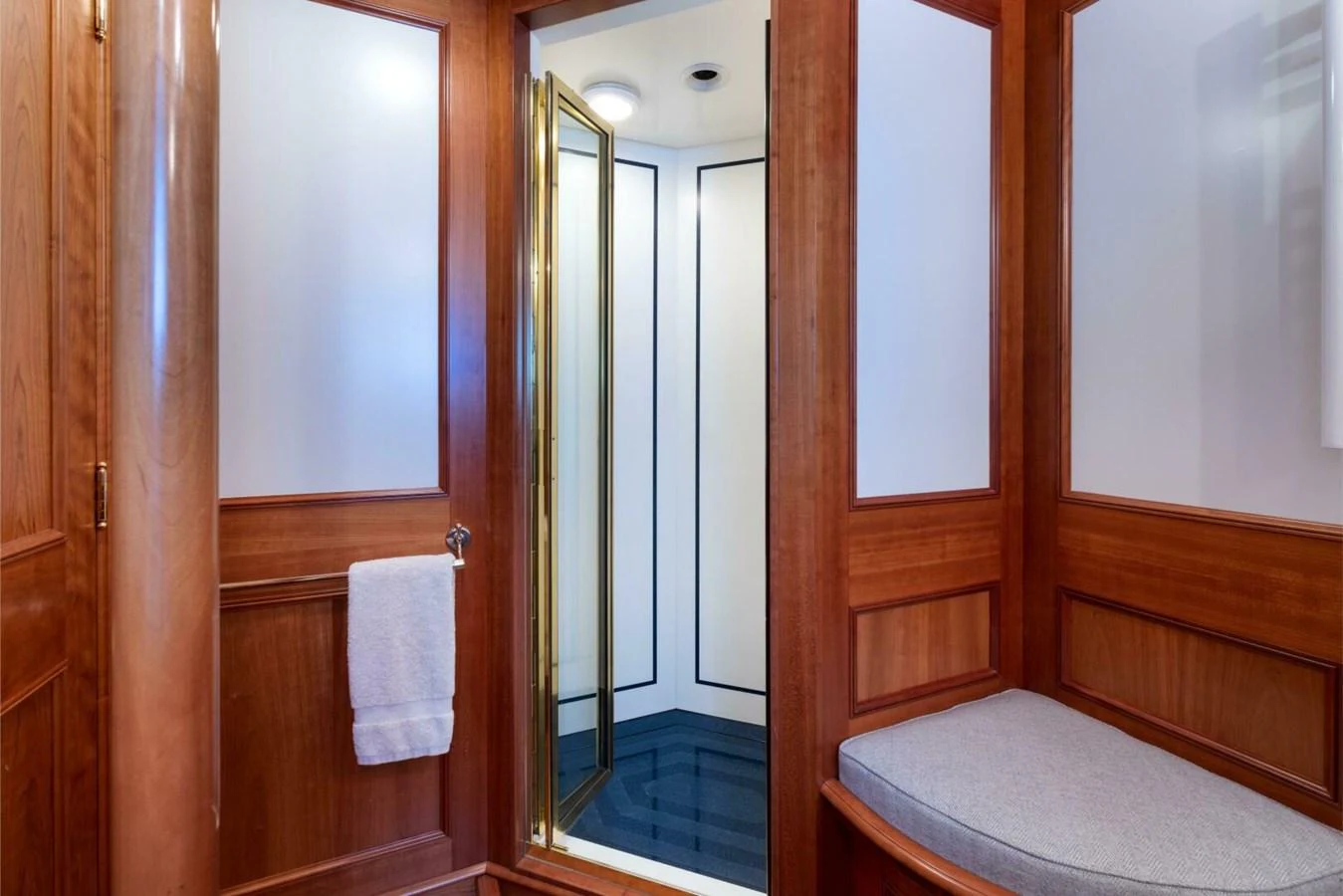 The yacht's bathroom features elegant wood paneling and a modern shower with a glass door. aboard CATALINA Yacht for Sale