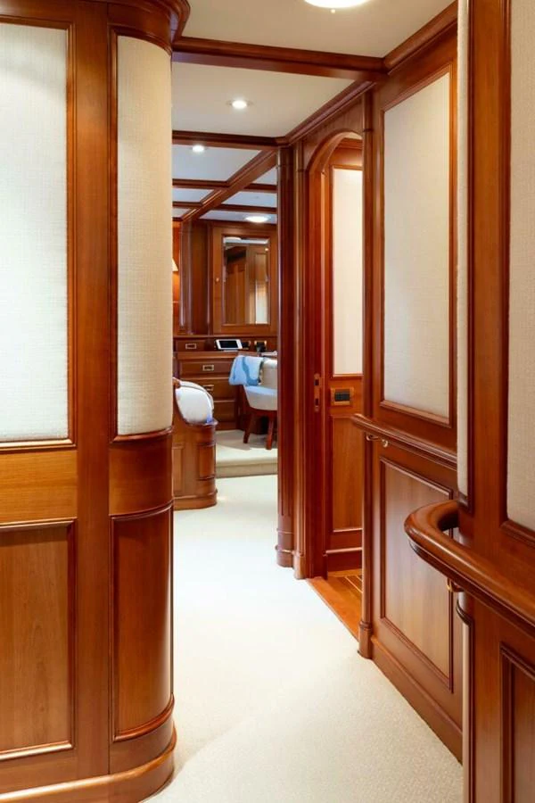 A luxurious hallway with rich wood paneling leading to a well-appointed room. aboard CATALINA Yacht for Sale