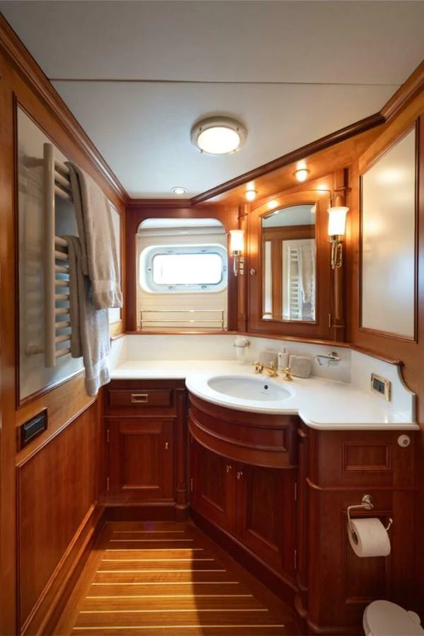 The yacht's bathroom features elegant wooden cabinetry and modern fixtures, creating a warm and inviting space. aboard CATALINA Yacht for Sale