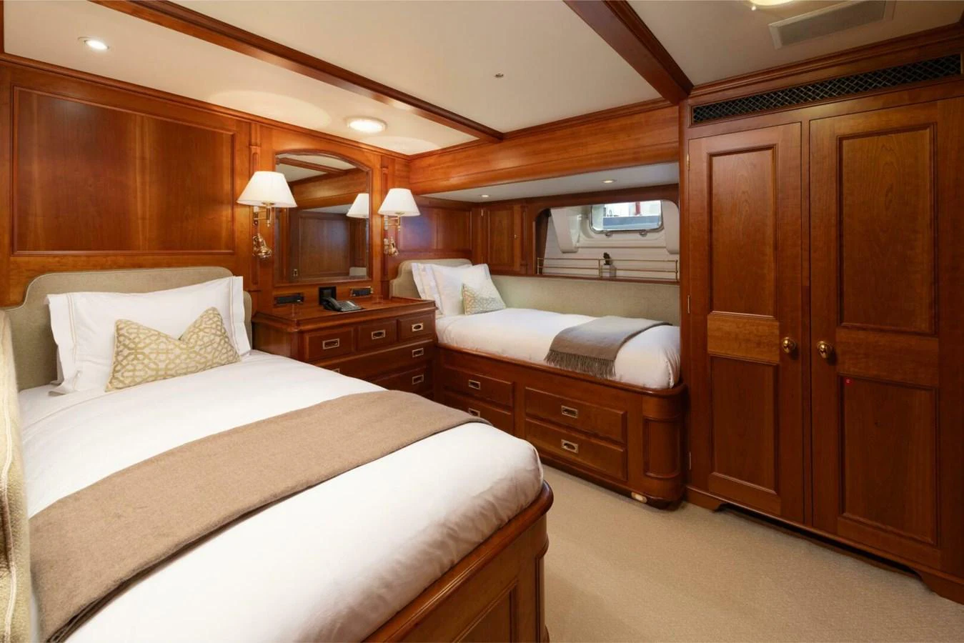 The guest stateroom features twin beds with elegant wooden cabinetry and soft lighting. aboard CATALINA Yacht for Sale
