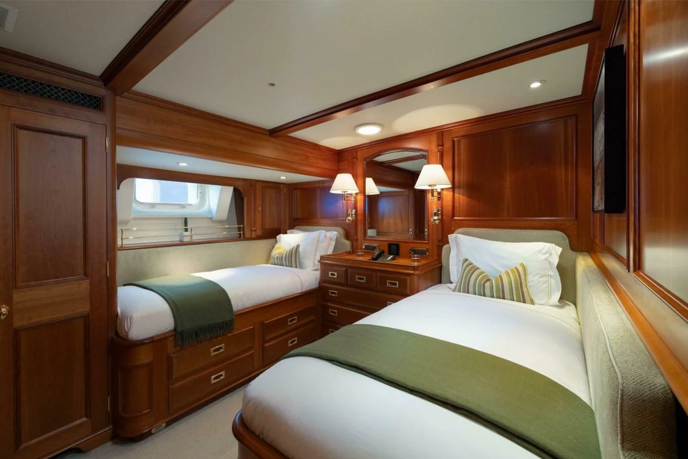 The twin stateroom features elegant wood paneling and cozy twin beds with plush bedding. aboard CATALINA Yacht for Sale