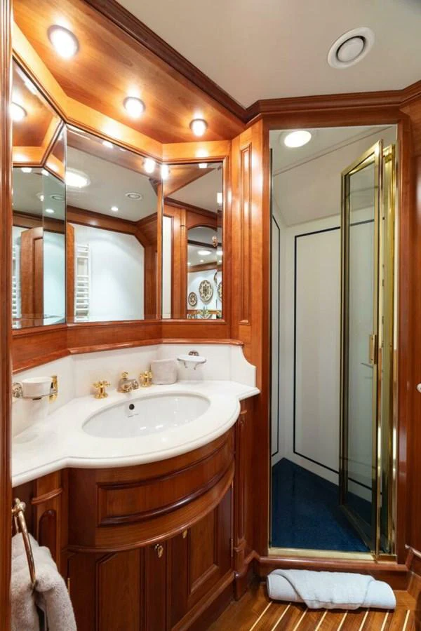 The yacht's bathroom features elegant wood finishes and a spacious shower area. aboard CATALINA Yacht for Sale