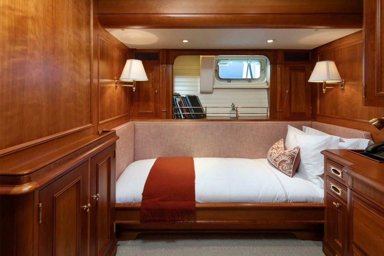 The guest cabin features a cozy single bed with elegant wooden furnishings and a small window for natural light. aboard CATALINA Yacht for Sale
