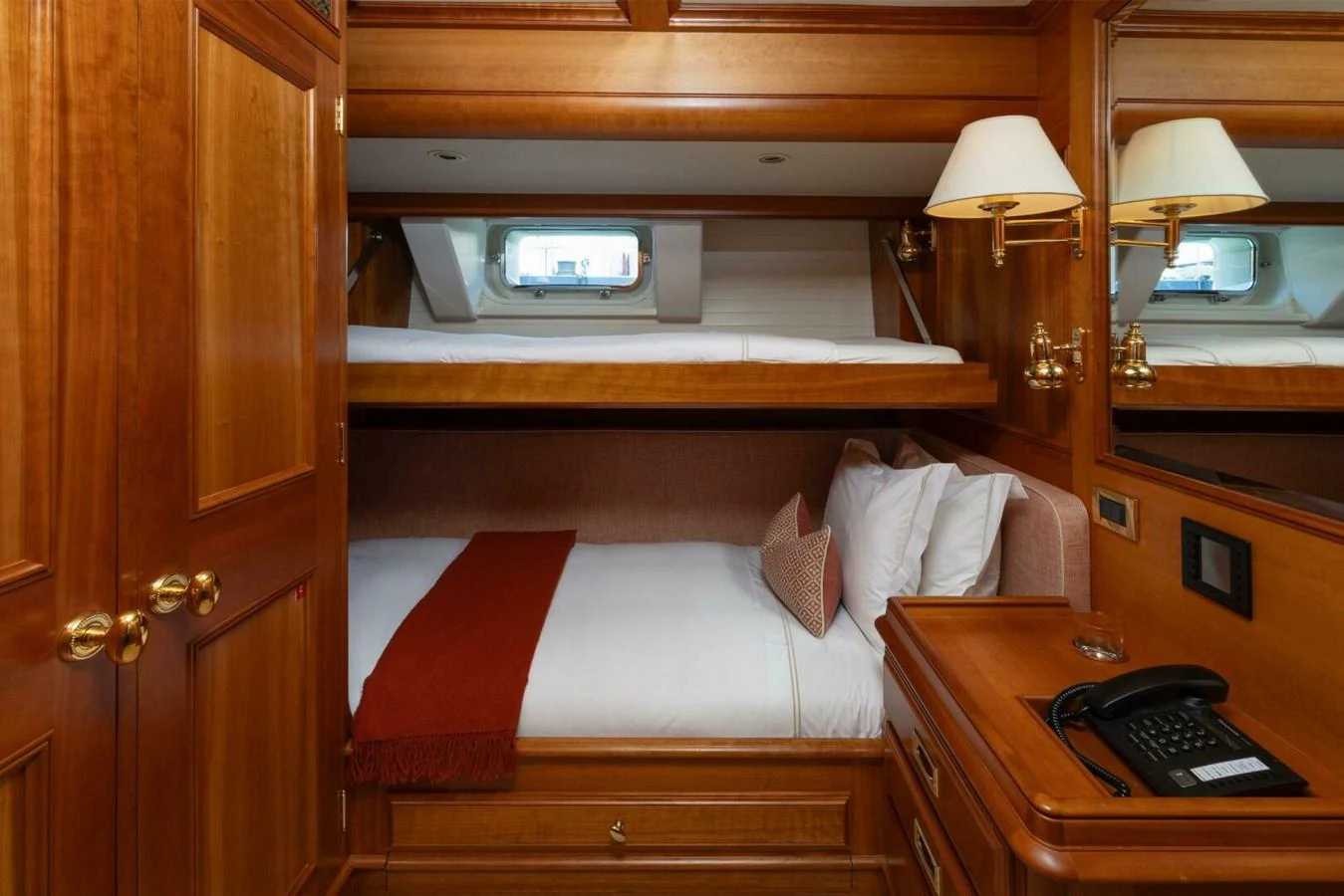 A cozy guest cabin with wooden furnishings and a bunk bed setup. aboard CATALINA Yacht for Sale