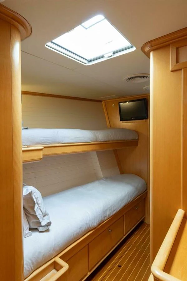 A cozy bunk cabin with natural wood finishes and a skylight. aboard CATALINA Yacht for Sale