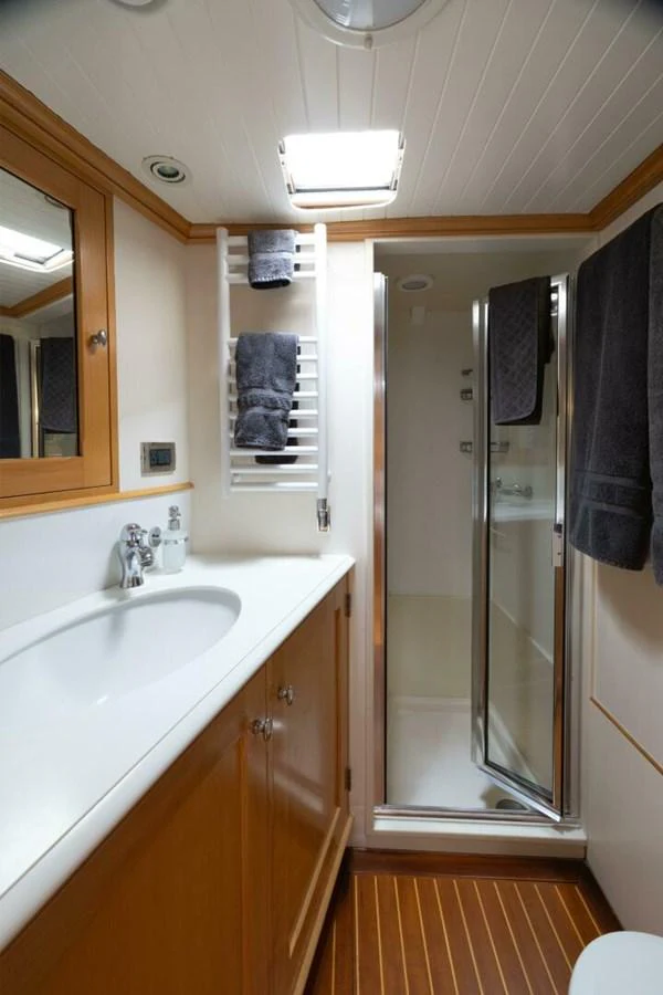 The yacht's bathroom features a sleek design with a spacious shower and elegant wood finishes. aboard CATALINA Yacht for Sale
