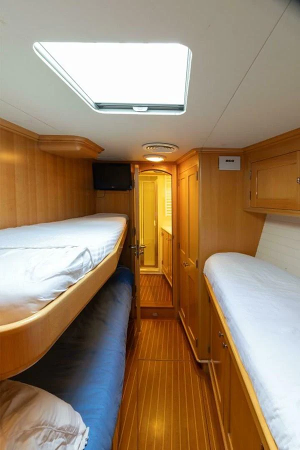 The cozy cabin features twin bunk beds and warm wooden finishes, creating a comfortable and inviting space. aboard CATALINA Yacht for Sale
