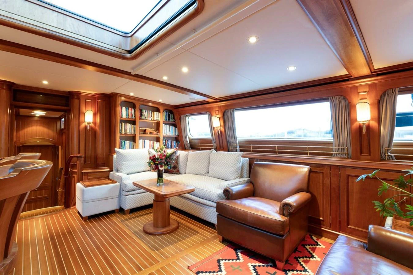 The yacht's salon features elegant wood paneling, comfortable seating, and ample natural light. aboard CATALINA Yacht for Sale