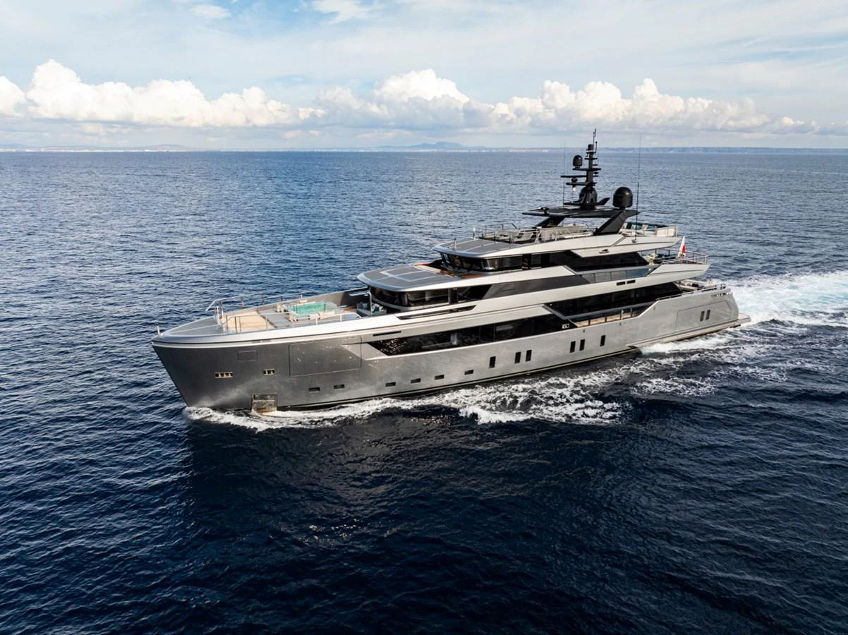 A sleek and modern yacht cruising on open waters under a partly cloudy sky. aboard PACIFIC PEARL Yacht for Sale