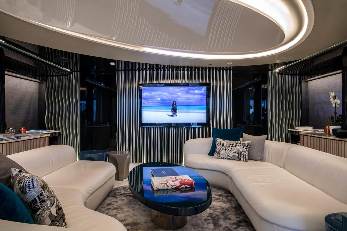 The yacht's salon features a luxurious seating area with a large TV and modern decor. aboard PACIFIC PEARL Yacht for Sale