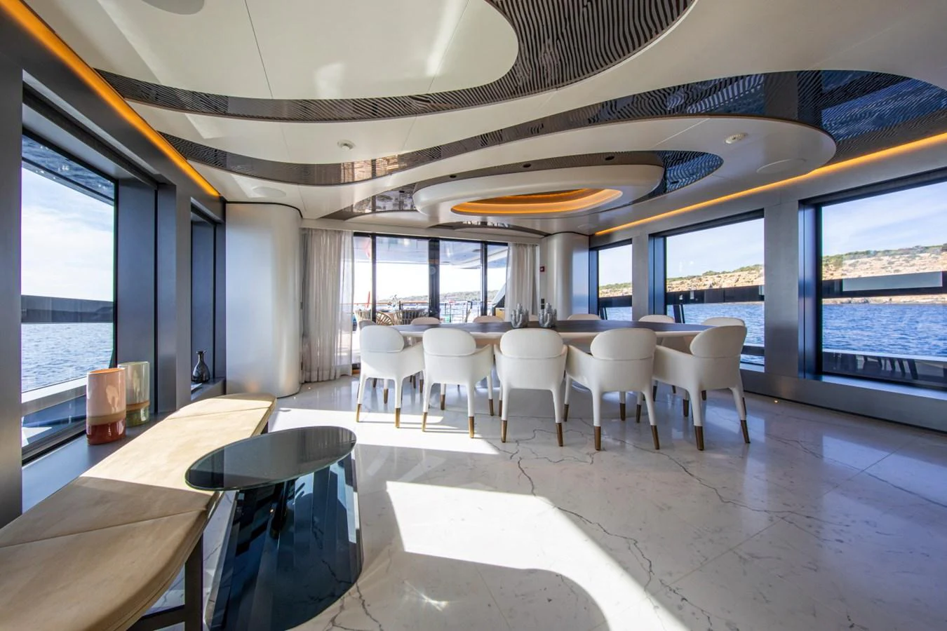 The yacht's dining area features a modern design with large windows offering panoramic ocean views. aboard PACIFIC PEARL Yacht for Sale
