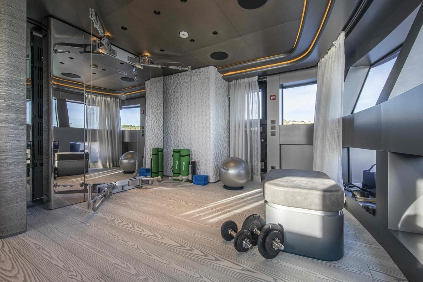The yacht features a well-equipped gym with modern fitness equipment and ample natural light. aboard PACIFIC PEARL Yacht for Sale