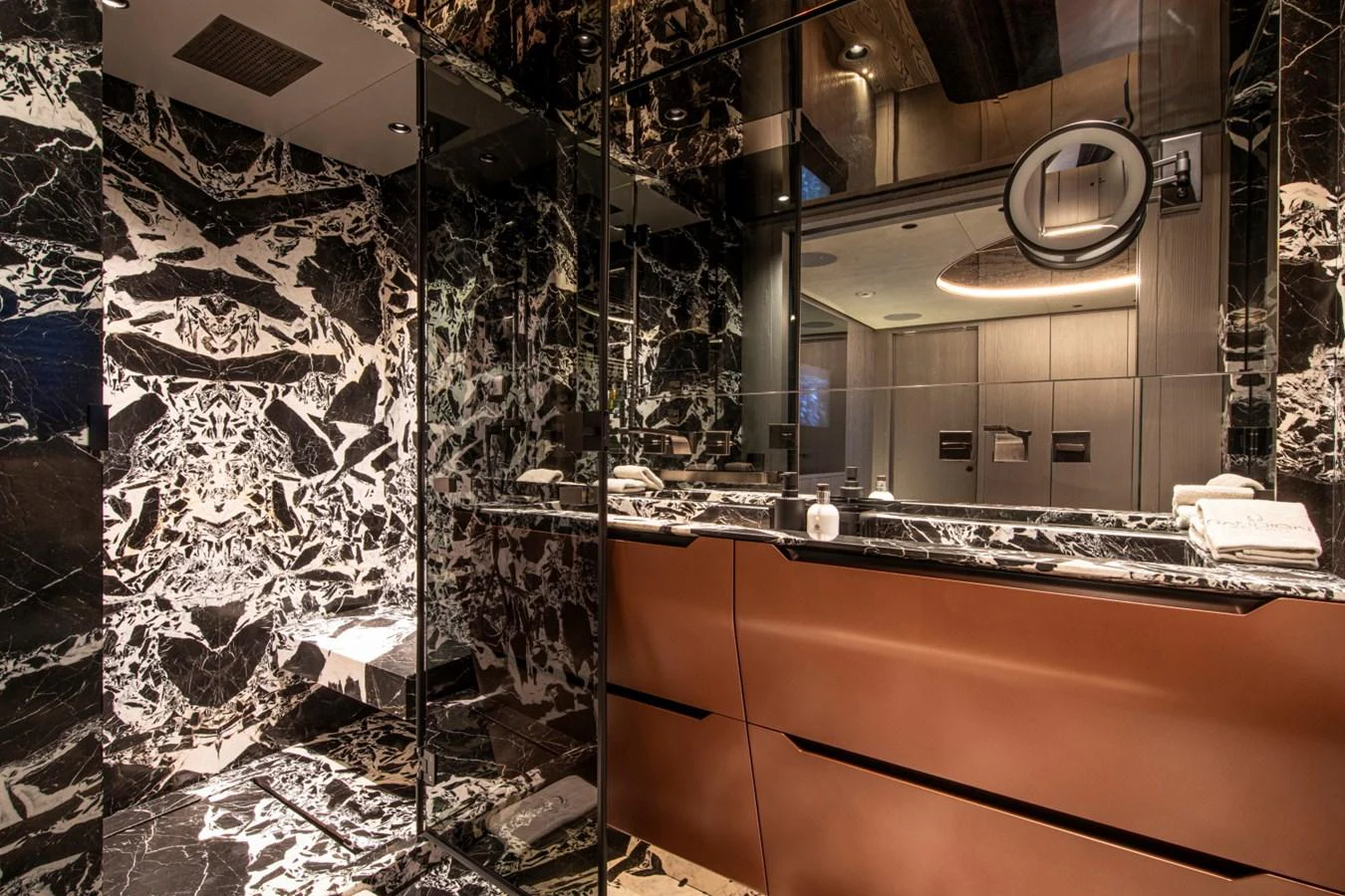 The yacht's bathroom features luxurious black marble and modern fixtures. aboard PACIFIC PEARL Yacht for Sale