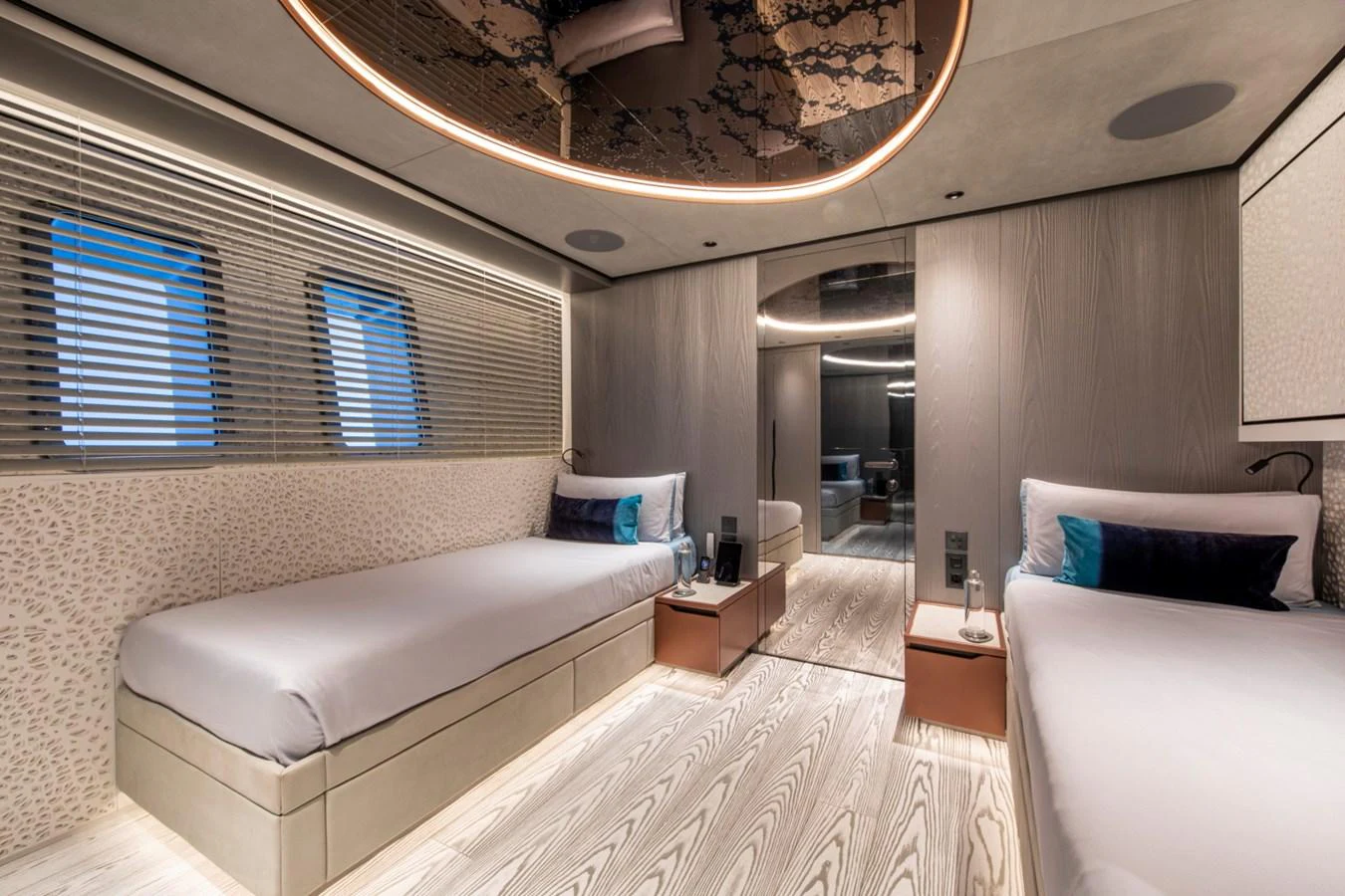 The guest stateroom features twin beds, modern decor, and ambient lighting for a luxurious stay. aboard PACIFIC PEARL Yacht for Sale
