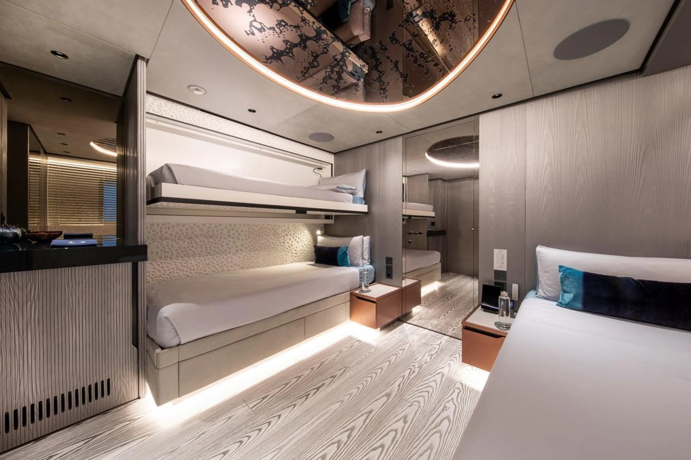 The guest stateroom features modern design with bunk beds and ambient lighting. aboard PACIFIC PEARL Yacht for Sale