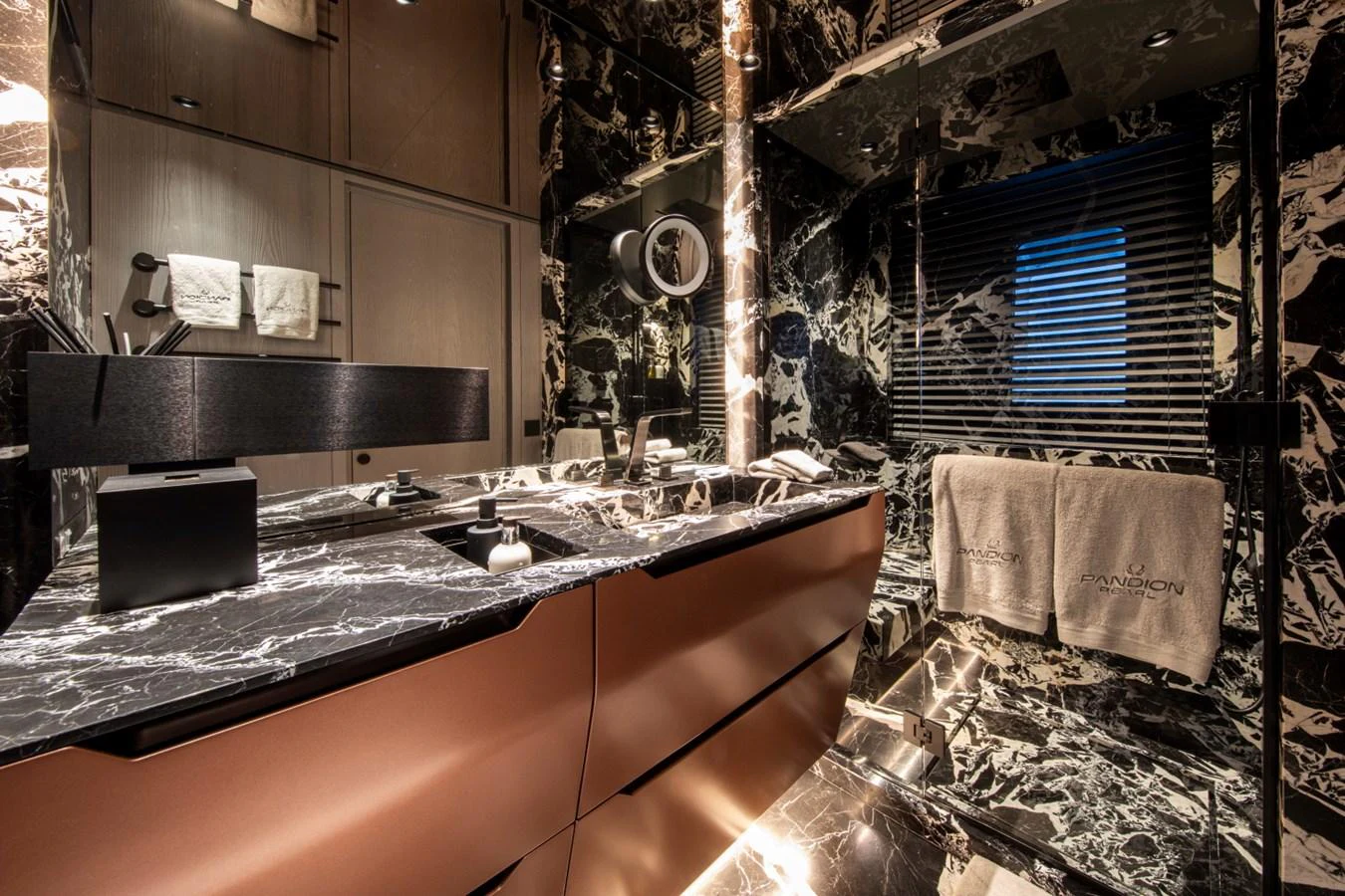 This luxurious yacht bathroom features elegant black marble surfaces and modern fixtures. aboard PACIFIC PEARL Yacht for Sale