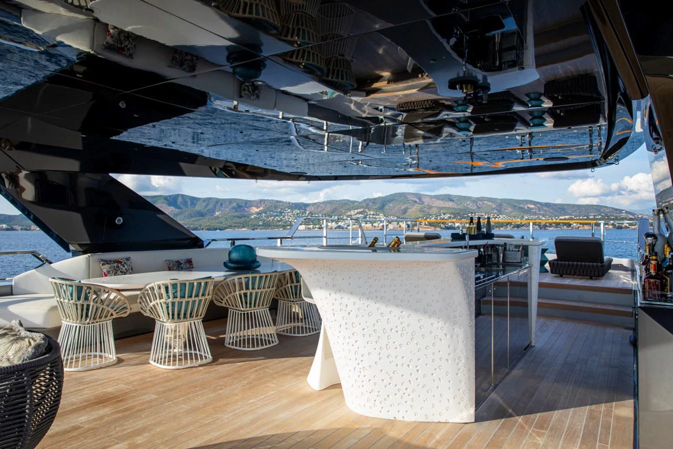 An elegant outdoor bar area on a yacht with stylish seating and a scenic view. aboard PACIFIC PEARL Yacht for Sale