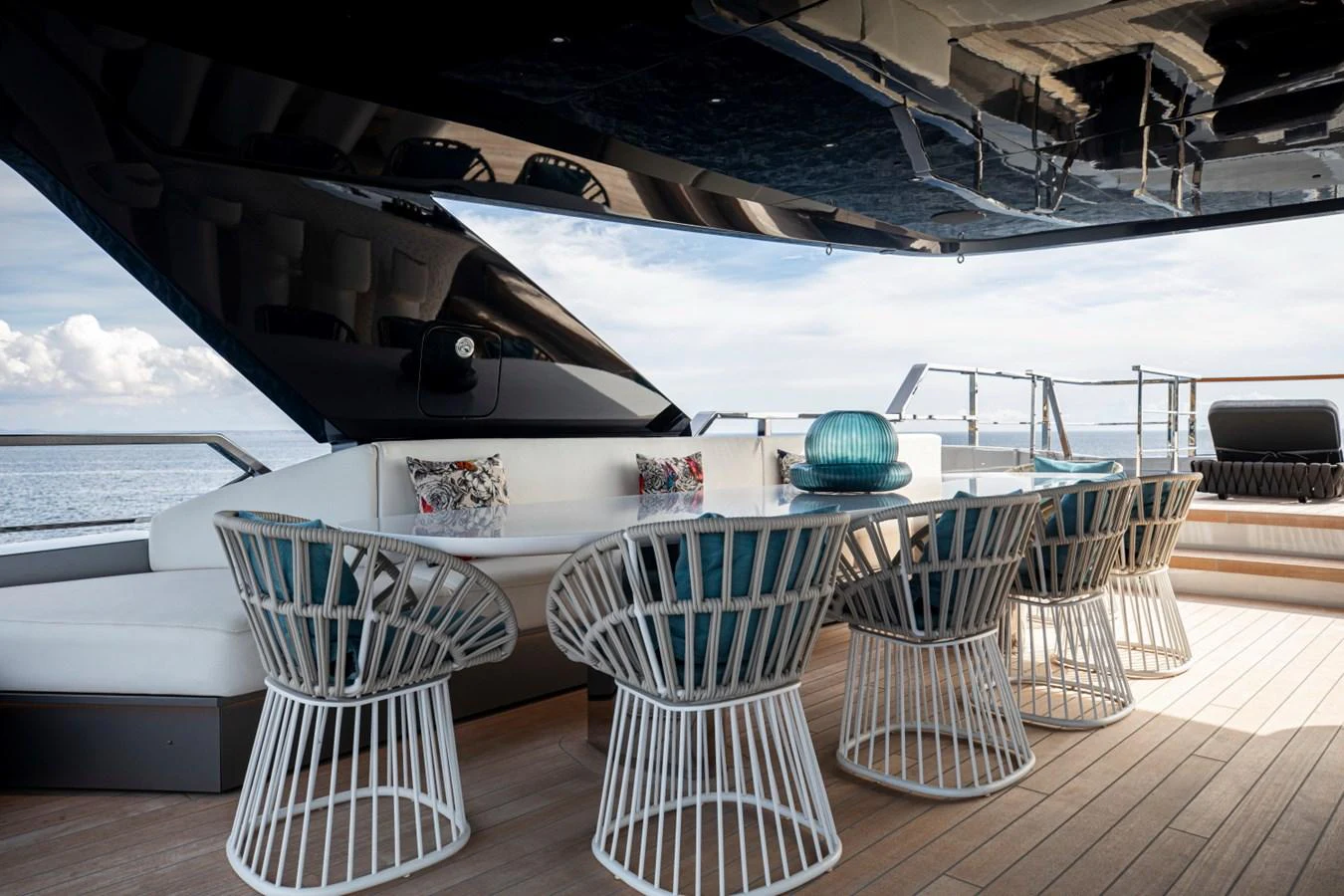 The aft deck features a stylish dining area with modern seating and a stunning ocean view. aboard PACIFIC PEARL Yacht for Sale