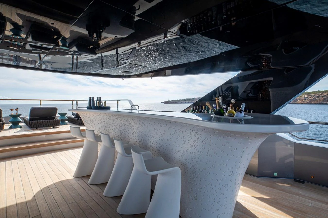 A stylish bar area on the deck of a yacht, offering a luxurious space for relaxation and socializing. aboard PACIFIC PEARL Yacht for Sale