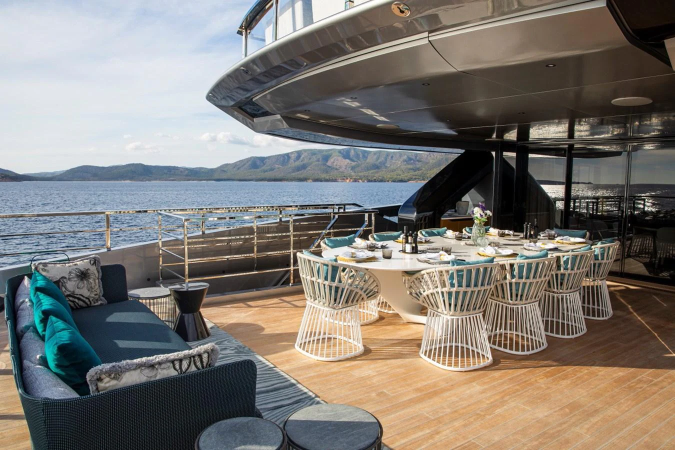 The aft deck features an elegant dining area with a large table and comfortable seating, perfect for al fresco meals with a stunning view. aboard PACIFIC PEARL Yacht for Sale