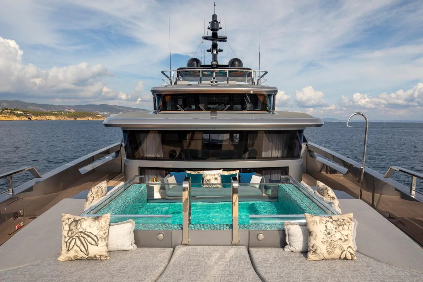 The yacht features a luxurious pool deck with a stunning view of the sea. aboard PACIFIC PEARL Yacht for Sale