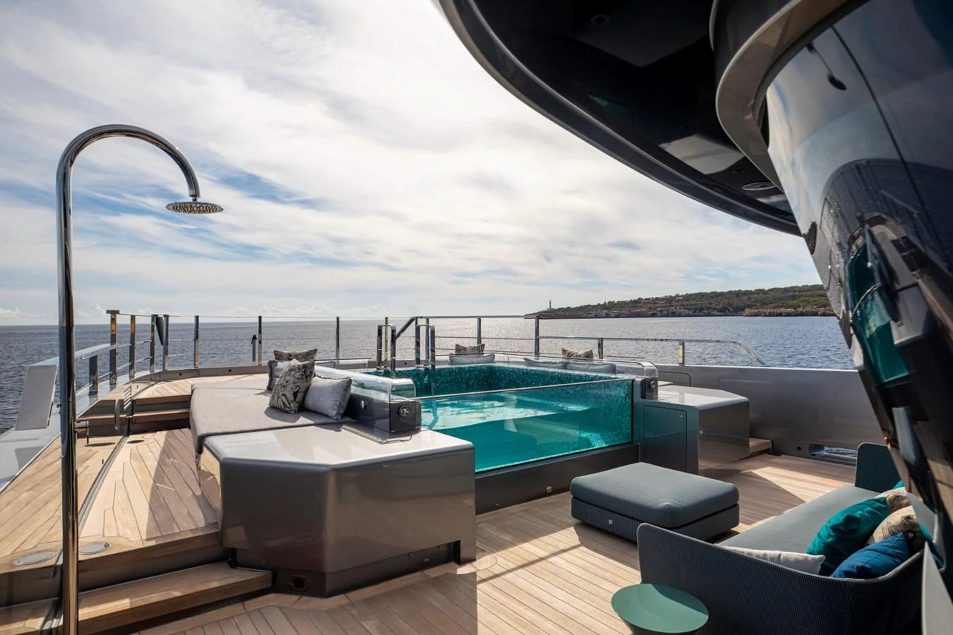 The sundeck features a luxurious pool with ample seating and stunning ocean views. aboard PACIFIC PEARL Yacht for Sale