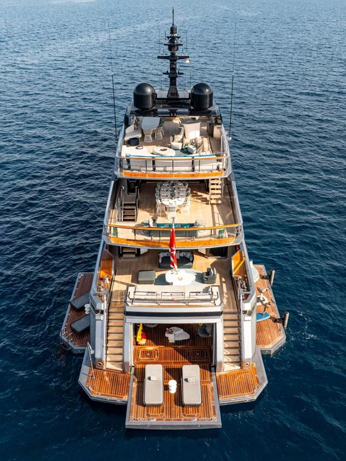 A luxurious yacht showcasing multiple decks with elegant outdoor seating and lounging areas, set against a serene ocean backdrop. aboard PACIFIC PEARL Yacht for Sale