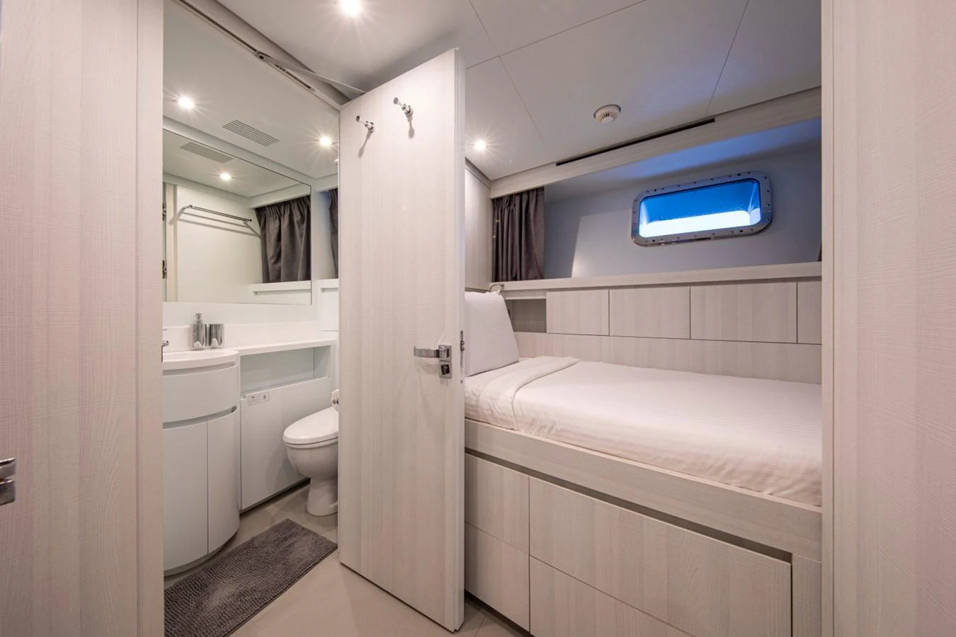 A cozy guest cabin featuring a single bed and an ensuite bathroom. aboard PACIFIC PEARL Yacht for Sale
