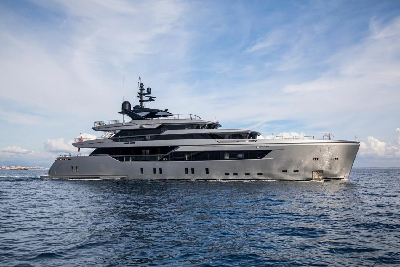 A sleek and modern yacht cruising on calm waters under a clear sky. aboard PACIFIC PEARL Yacht for Sale