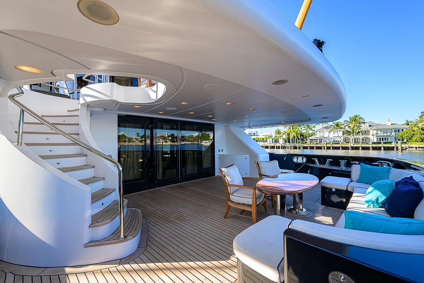 The aft deck features a comfortable seating area with a round table and a staircase leading to the upper deck. aboard SEASCAPE V Yacht for Sale