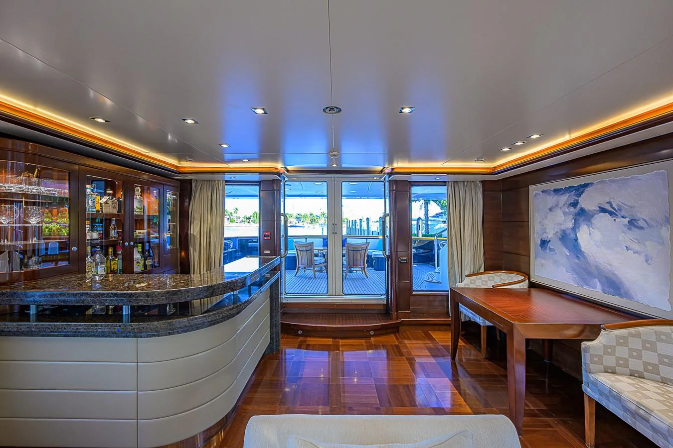 The yacht's salon features a luxurious bar area, elegant seating, and large windows offering stunning views. aboard SEASCAPE V Yacht for Sale