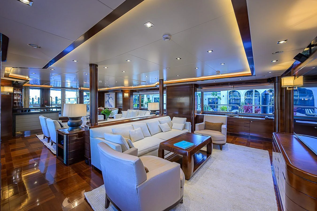 The salon features luxurious seating with elegant lighting and large windows offering stunning views. aboard SEASCAPE V Yacht for Sale