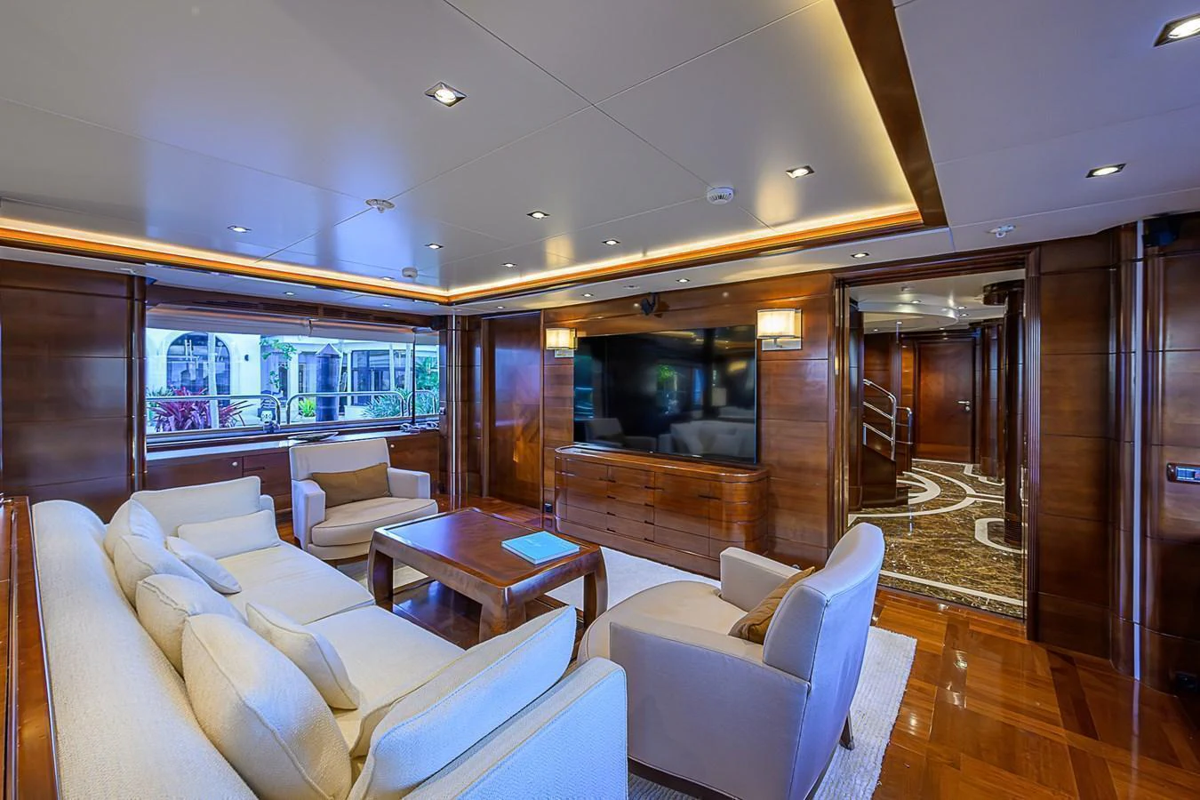 The yacht's salon features plush seating, a large flat-screen TV, and elegant wood paneling. aboard SEASCAPE V Yacht for Sale