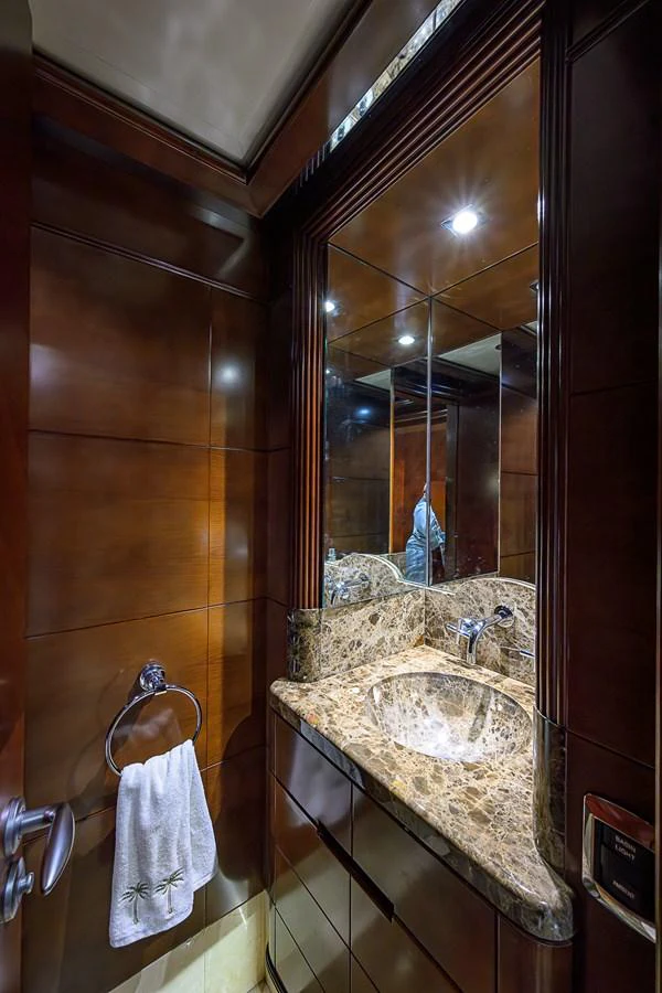 The yacht's bathroom features luxurious wood paneling and a marble countertop. aboard SEASCAPE V Yacht for Sale