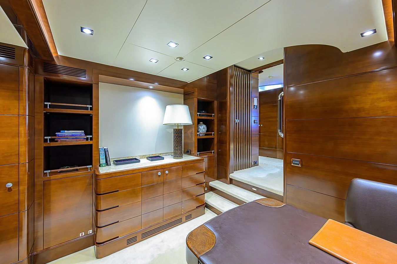 The yacht's interior features a sophisticated and well-lit office space with elegant wooden cabinetry and modern lighting. aboard SEASCAPE V Yacht for Sale